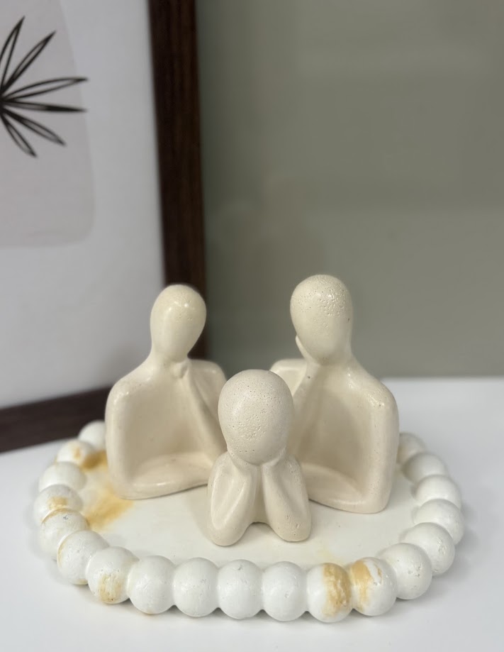 Trio de figuras familiares esculturais sobre bandeja artesanal